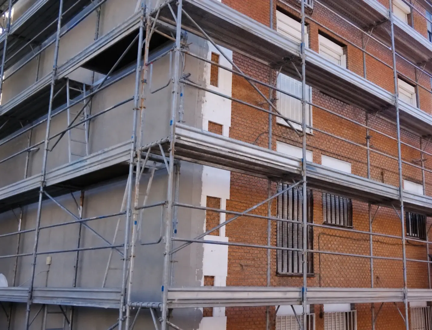 Instalación de aislamiento SATE con andamios en una fachada